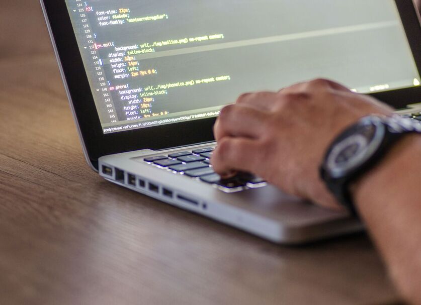 Detail-picture of a man coding in his laptop