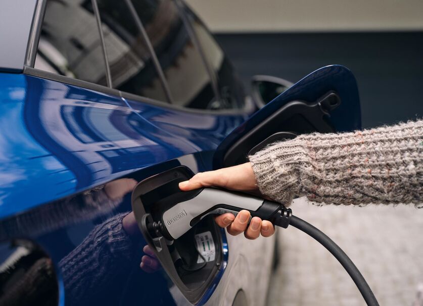 Charging cable plugged into blue electric car