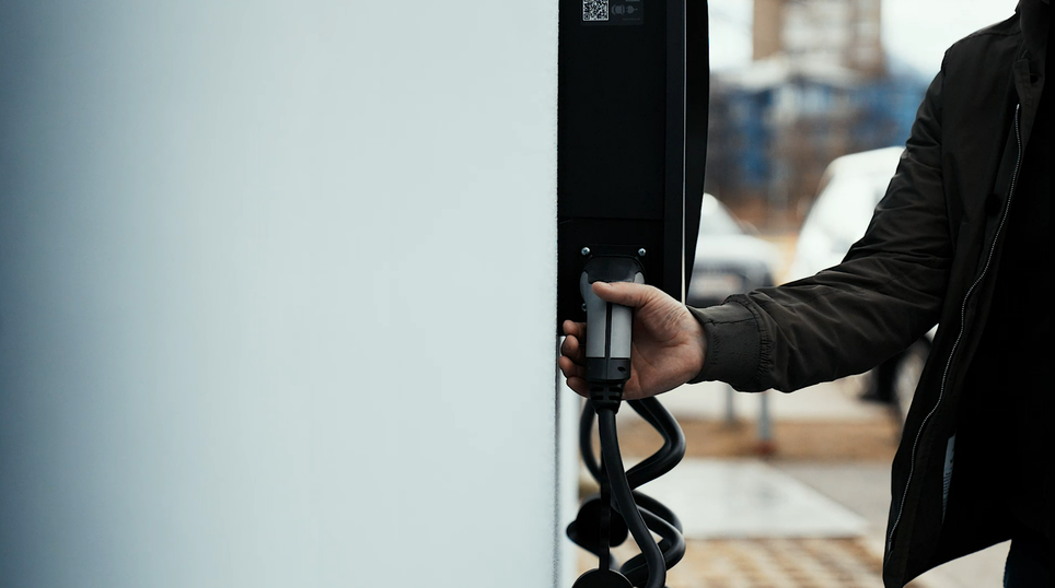 A man holds a connector of a wallbox