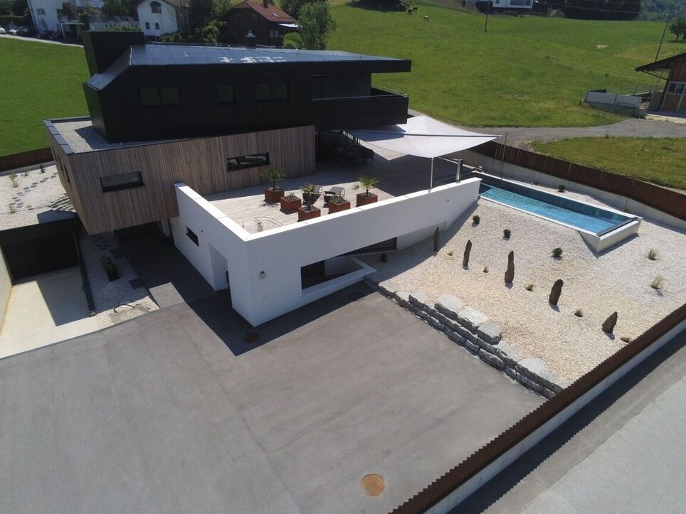 Flight view of the private hause with a facade made out of dummy solar panels